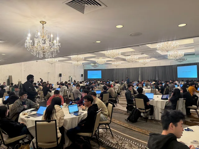 Competitors trading on laptops in the hotel ballroom