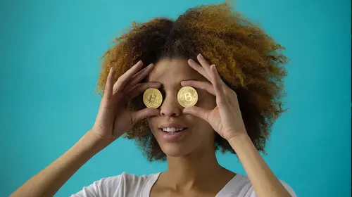 woman holding coins up to their eyes